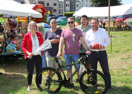 Die Kinderbelustigung beim Schützenfest in Rheinberg gibt es seit 1860. Andrea Kabs-Schlusen vom Hauptsponsor Sparkasse am Niederrhein besuchte die Spielwiese. Dort wurde sie vom Präsidenten des Kinderbelustigungskomitees Dette Ecker, dem Helfer Jens Gardemann (mit dem Hauptgewinn beim Kletterstangen-Spiel) und Vizepräsident Jan Dirk Döppers begrüßt. Rechts im Bild: Benjamin Waldmann von der Sparkasse.