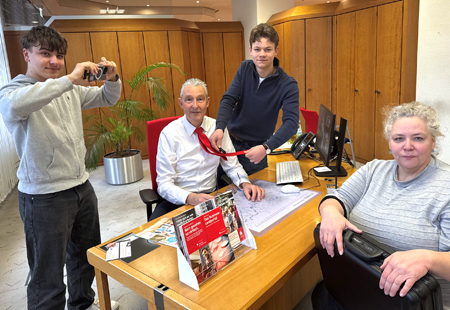 Das Adolfinum beim Videodreh für ‚Knete für die Fete‘ in der Sparkassen-Hauptstelle: Brandon Helleckes (l.) fokussiert auf Regine Meyering (r.) und Adrian Schulz steckt Holger Schmitz ein Mikrofon an.